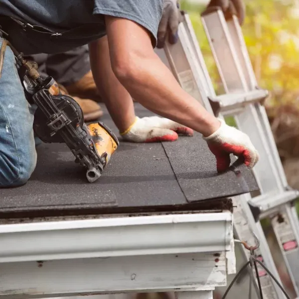 Roofing contractor installing asphalt shingles during a residential roof replacement project in Louisville, KY